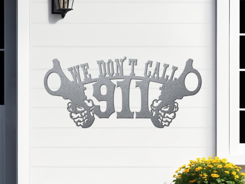 Silver decorative metal sign with 'We Don't Call 911' text on a white wall.